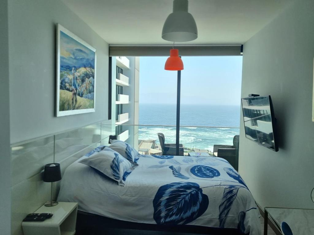 安托法加斯塔Puerto Nuevo Antofagasta的一间卧室设有一张床,享有海景