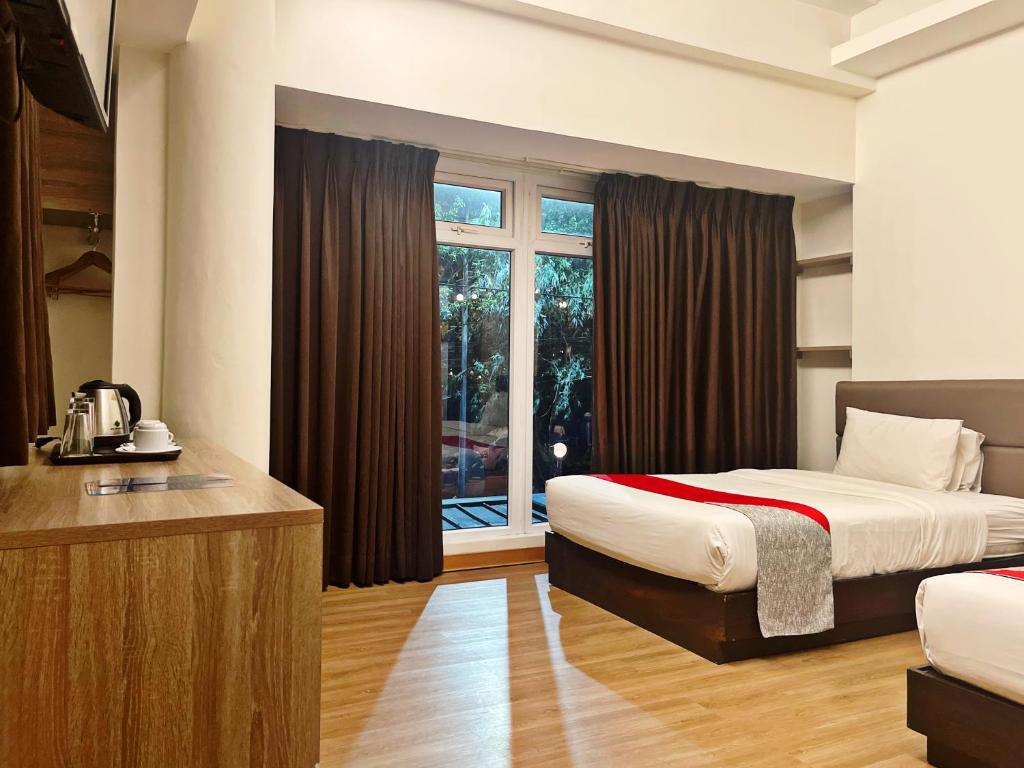 马尼拉Airo Hotel Manila的酒店客房设有两张床和窗户。