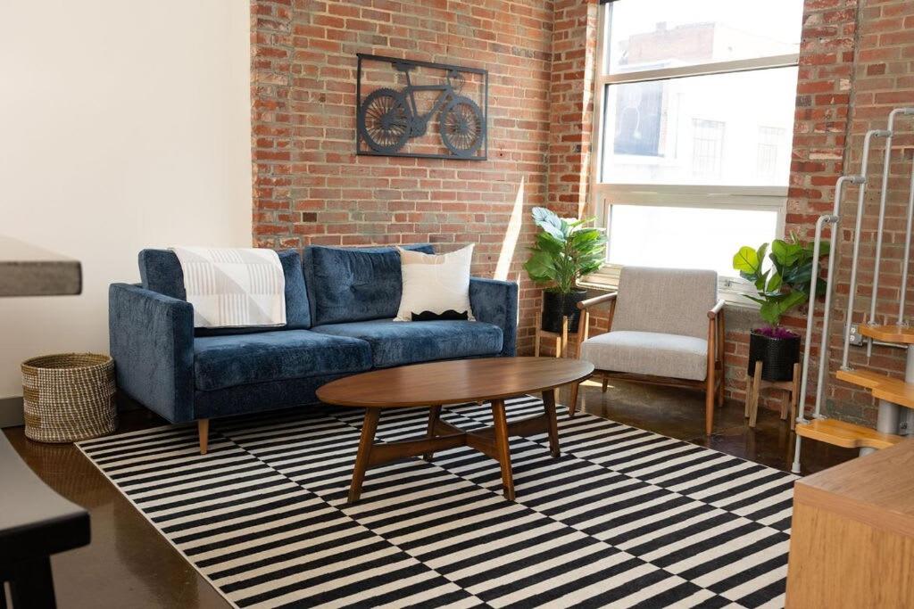 罗阿诺Trendy 1 Br Loft Apt Downtown With Exposed Brick的客厅配有蓝色的沙发和桌子