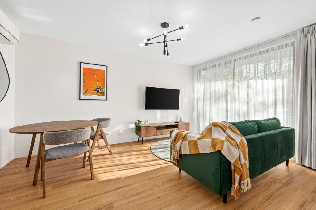 瑟尔Peppertree Apartments的客厅配有绿色沙发和桌子