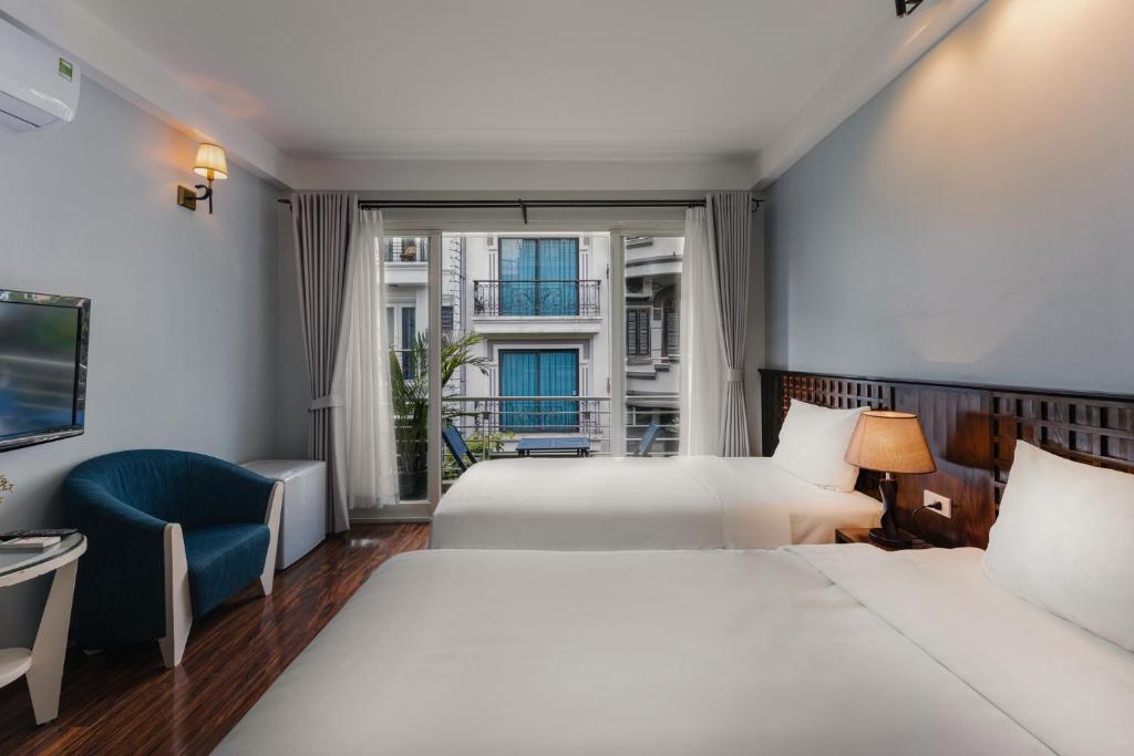 河内Cheers Hostel Hanoi的酒店客房设有两张床和窗户。