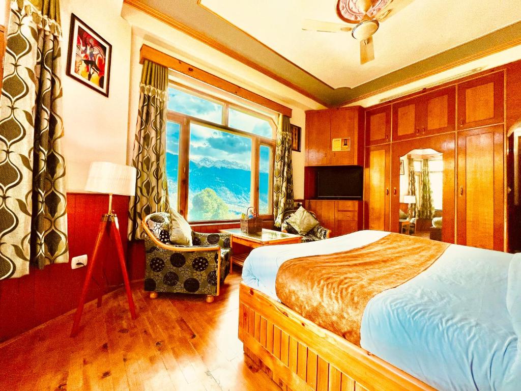 马拉里Shree Ram Cottage, Manali ! 1,2,3 Bedroom Luxury Cottages Available的一间卧室设有一张床和一个大窗户