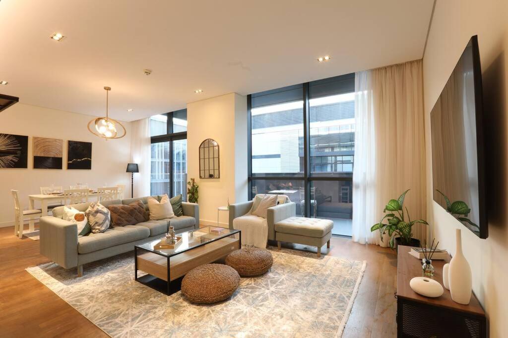 迪拜Manzil - Sleek 2BR nr Downtown & Dubai Mall的客厅配有沙发和桌子