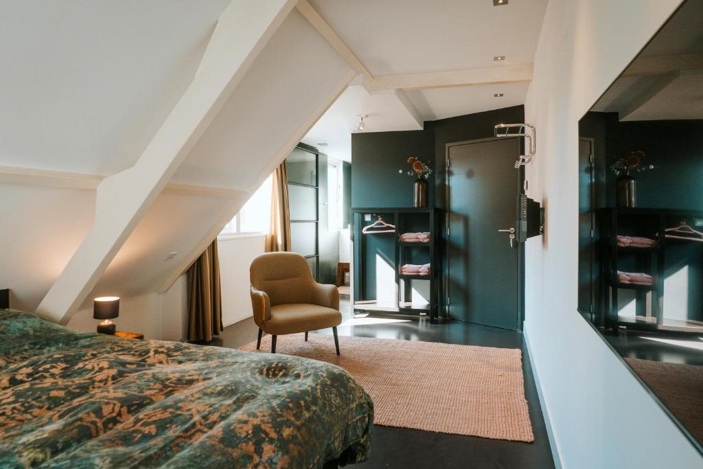 登堡Texels Goud Deluxe Suites的一间卧室配有一张床和一把椅子