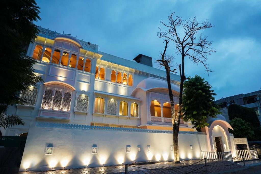 斋浦尔Dev Mahal - A Boutique Heritage Hotel的一座白色的大建筑,灯火通明