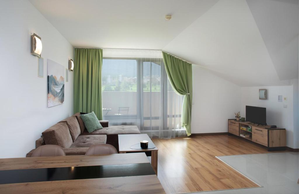 拉兹洛格Pirin Bliss Apartment Ski, Spa and Relax at Terra Complex的带沙发和大窗户的客厅