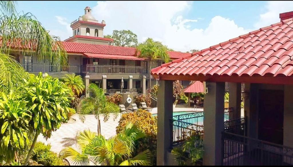 坦帕Red Roof Inn PLUS & Suites Tampa的一座带游泳池的度假村和一座带塔楼的建筑