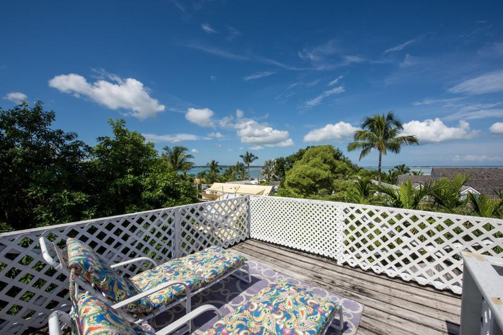 哈勃岛Watercolor home的阳台配有椅子,享有海景。