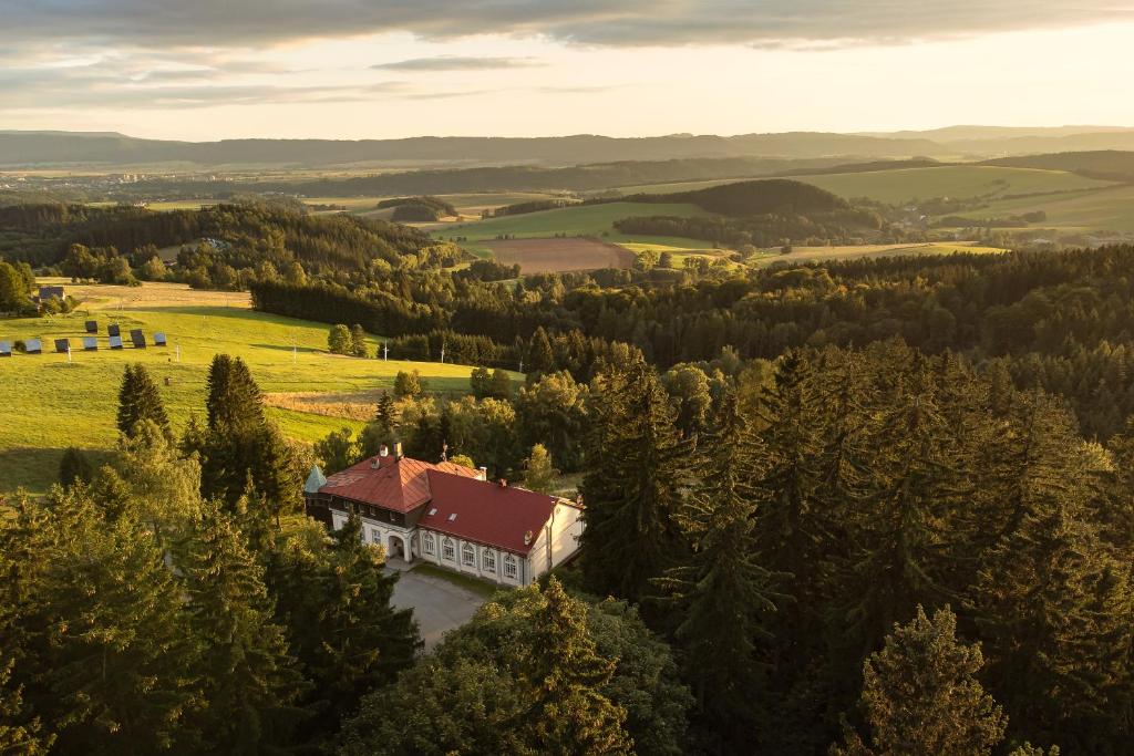 布劳莫夫Hotel Zámeček Janovičky的享有山谷中树木繁茂的房屋的空中景致