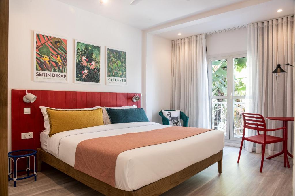 格兰贝伊Dodo Square的一间卧室设有一张大床和红色的墙壁