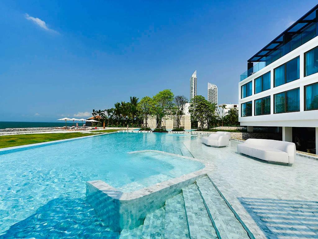 乔木提恩海滩Veranda Resort Pattaya - MGallery by Sofitel的大楼旁的大型游泳池