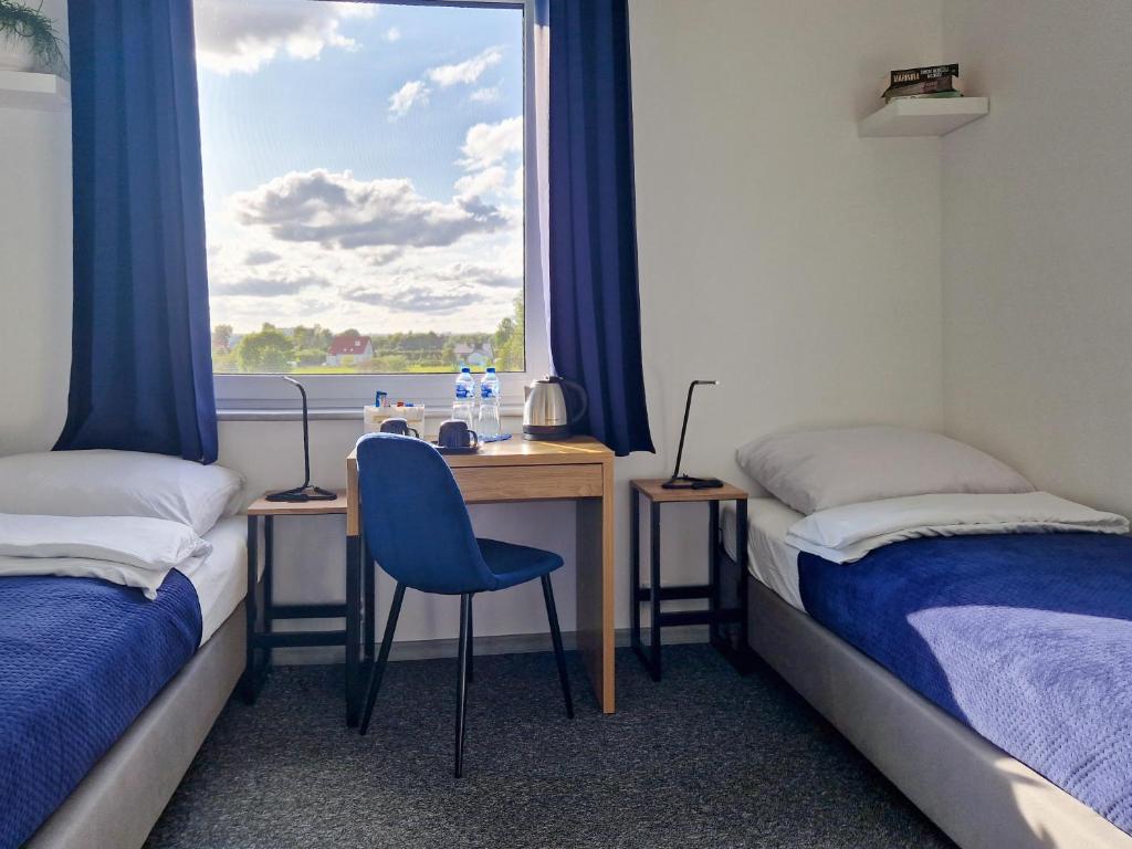 格但斯克Mile Gdansk Airport的客房设有两张床和一张带窗户的书桌。