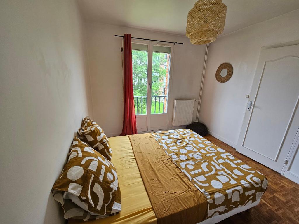 马恩河畔维列Cosy appartement près *RER et Disney, Paris的一间卧室设有一张床和一个窗口