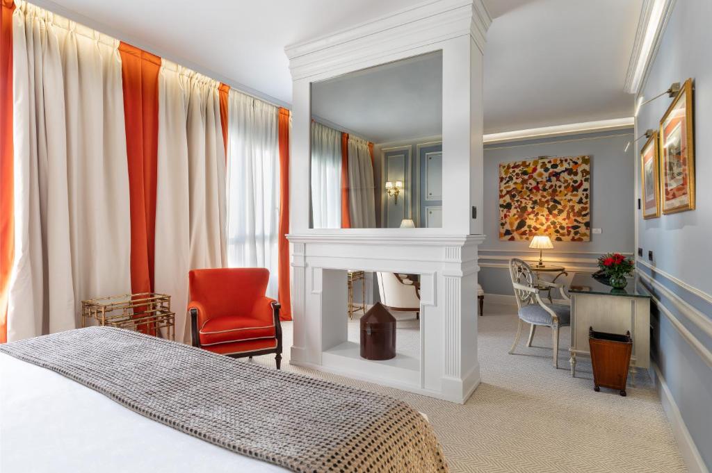 马德里Wellington Hotel & Spa Madrid的一间卧室配有一张床、一个壁炉和一张书桌