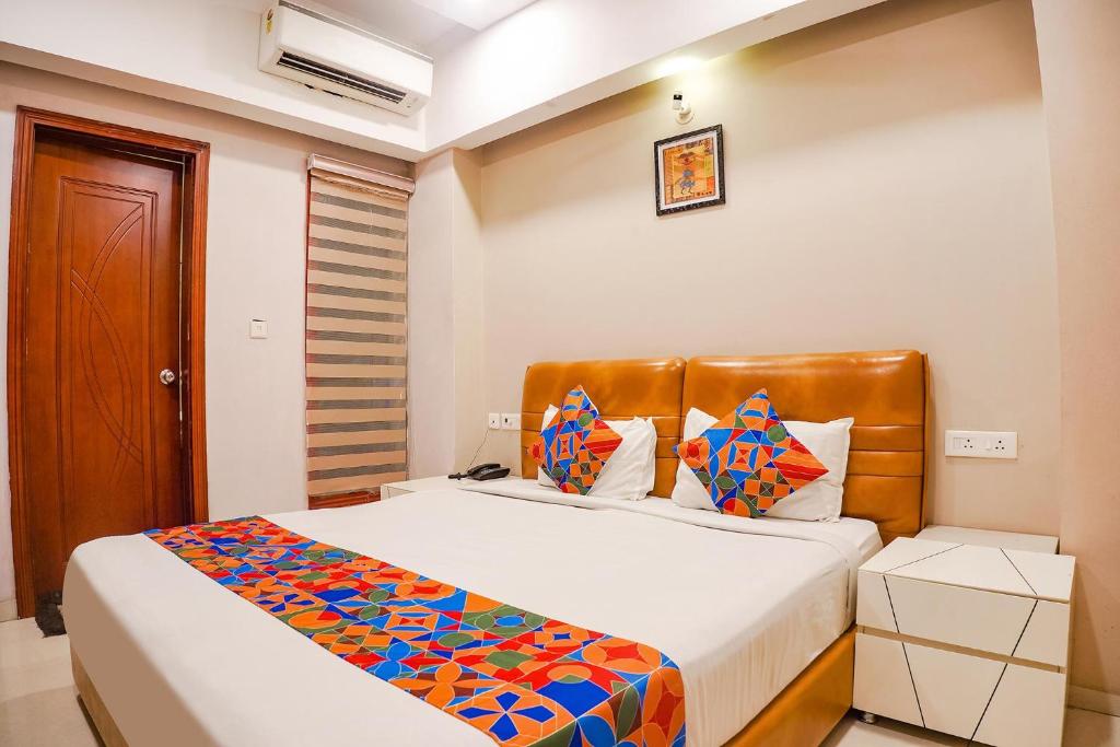博帕尔FabHotel Divine Casa的一间卧室配有一张大床和色彩缤纷的毯子