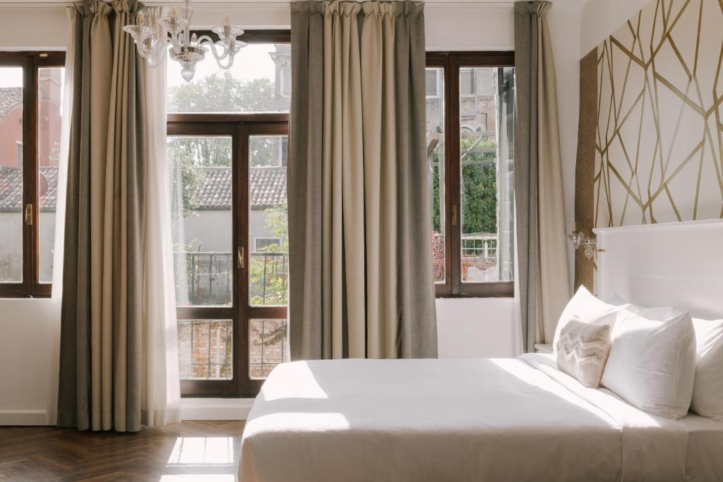 威尼斯Salute Palace powered by Sonder的卧室配有白色的床和窗户。