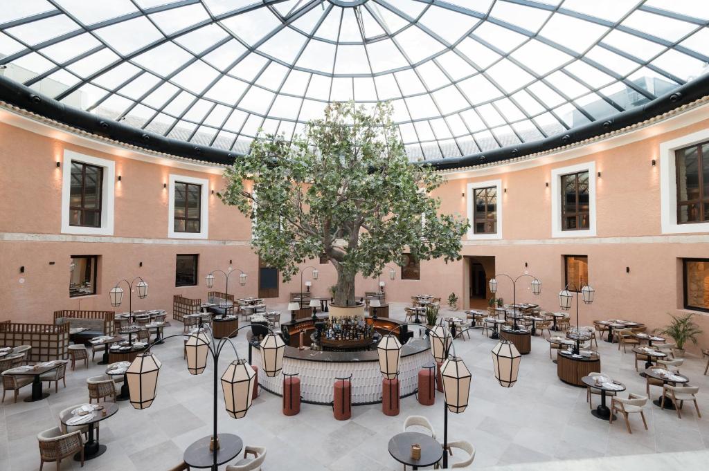 布里韦加Castilla Termal Brihuega的大房间设有桌椅和玻璃天花板
