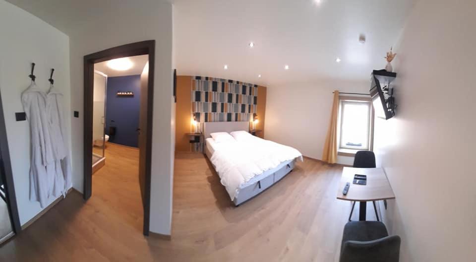 纳索尼厄Les Chambres de la Fromagerie d'Ambly的卧室配有一张白色的大床和一张桌子
