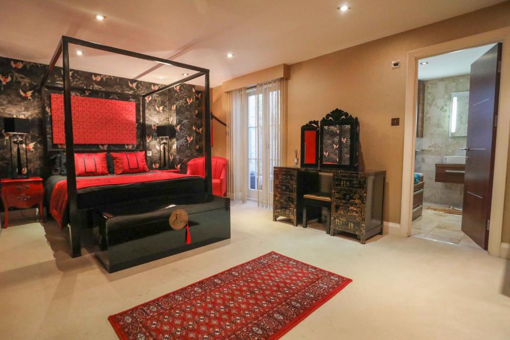 伦敦The London Nest: 2BR City Haven的一间卧室配有红色的床和镜子