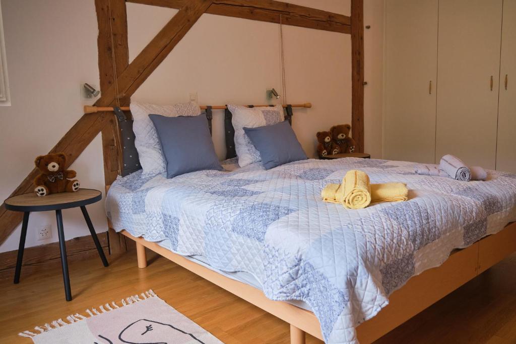 BaulmesÀ l'étape rêvée, charme, calme et nature的一间卧室配有一张带蓝色棉被的大床