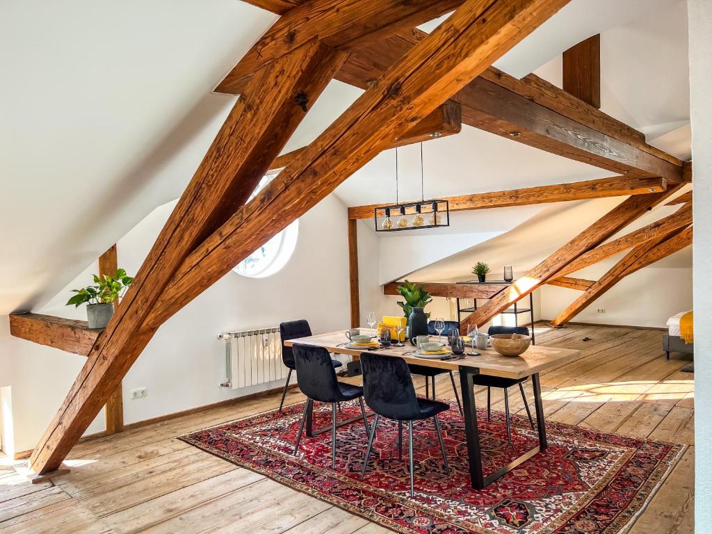 基姆湖畔普林Loft-Wohnung im Herzen von Prien - 100m2 - SmartTV的一间位于地毯上的带桌椅的用餐室