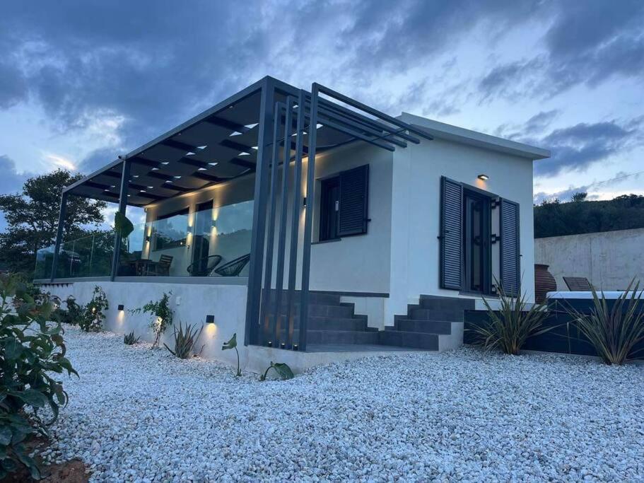 干尼亚Ek Ornelakis, Luxury Country House with Jacuzzi的一间白色的小房子,设有黑色窗户和楼梯