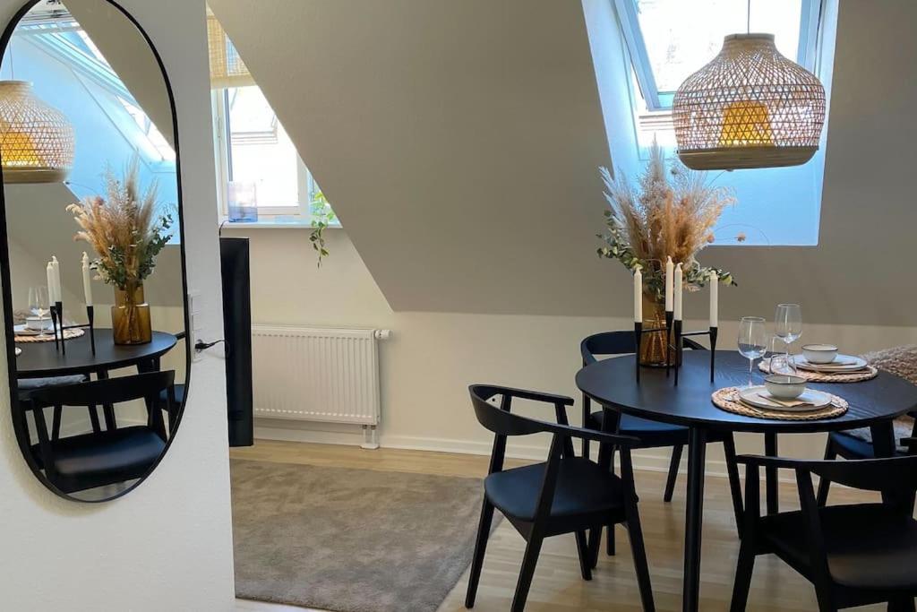 欧登塞Ophold i hjertet af Odense!的餐桌、椅子和镜子