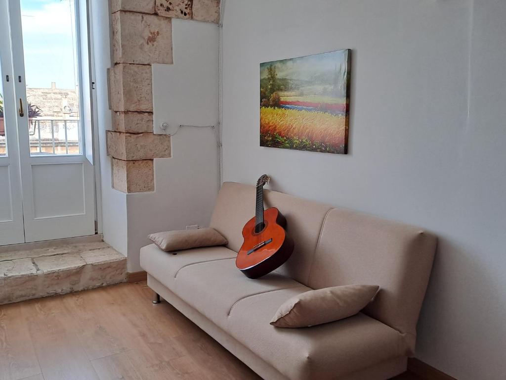 普蒂尼亚诺A Levante的客厅的沙发上的吉他
