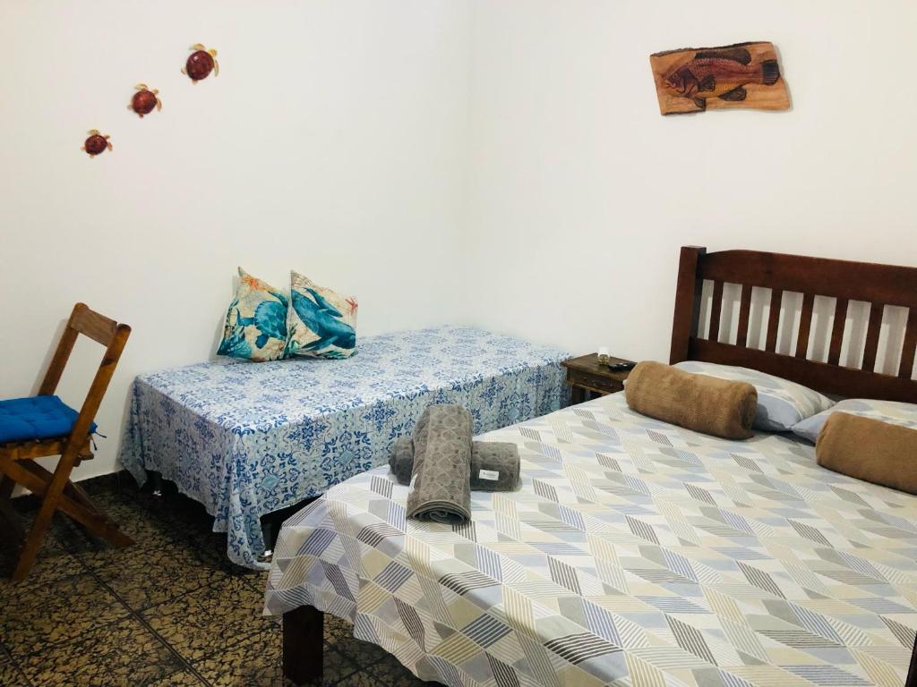 阿拉亚尔-杜卡布Suíte Trilha do Sol 2的一间卧室配有两张床和椅子