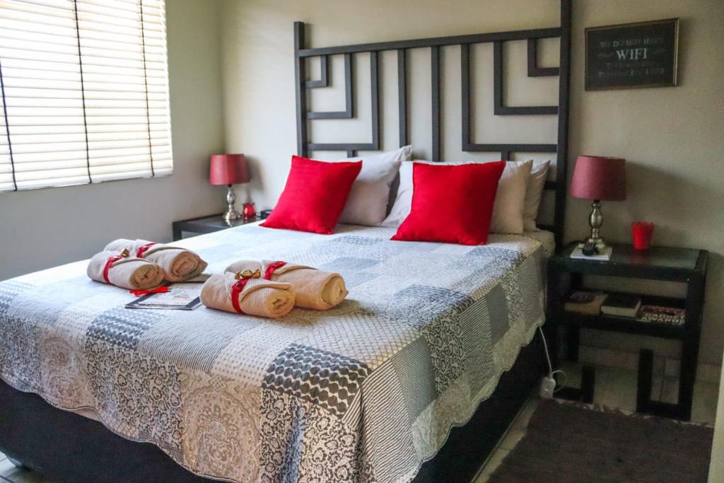 波切夫斯特鲁姆Tuiskoms & Toeka Guesthouse的一间卧室配有一张带红色枕头的大床