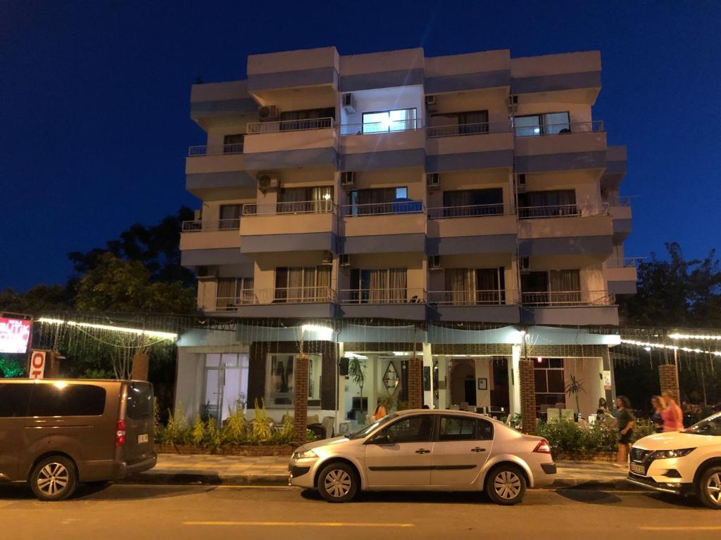 阿纳穆尔Anamur Butik Otel的两辆汽车晚上停在大楼前