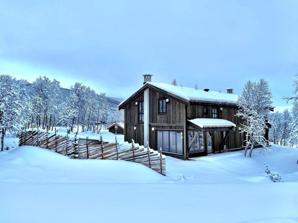 耶卢Budalstølen-ny og flott hytte-sentral beliggenhet的雪中小屋,有雪覆盖的树木
