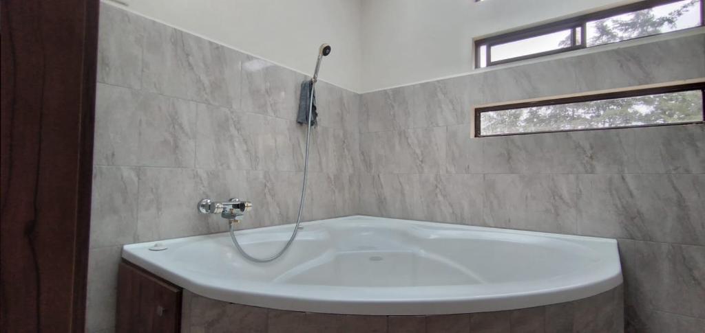 昆卡Casa Terra的带窗户的浴室内的白色浴缸