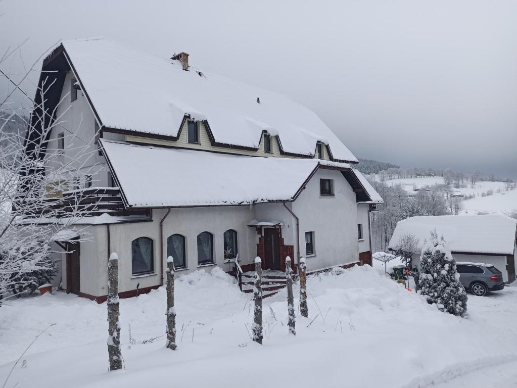 杜什尼基-兹德鲁伊Pokoje, kwatery prywatne przy stoku w Zieleńcu的屋顶上白雪的房子