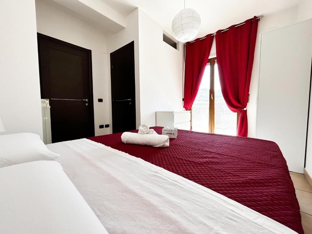 科森扎Sunrise Home的一间卧室配有一张带红色窗帘的大床
