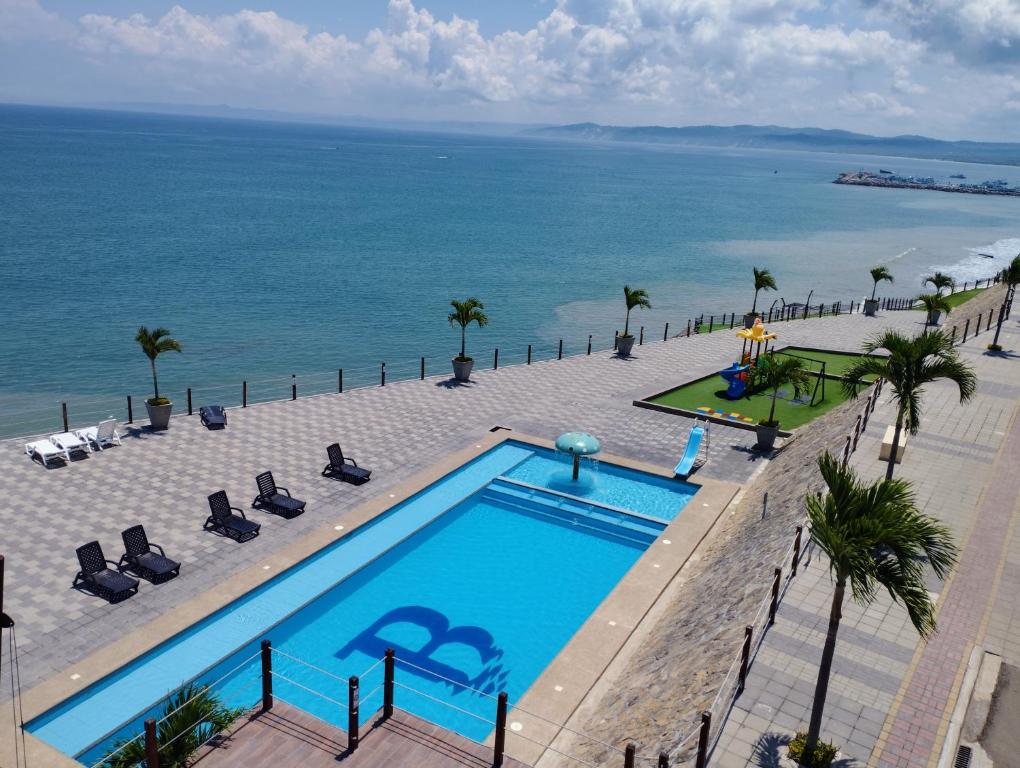 JaramijóPunta Blanca Beach Apartments Manta Coliving Ecuador的享有毗邻大海的游泳池的顶部景致