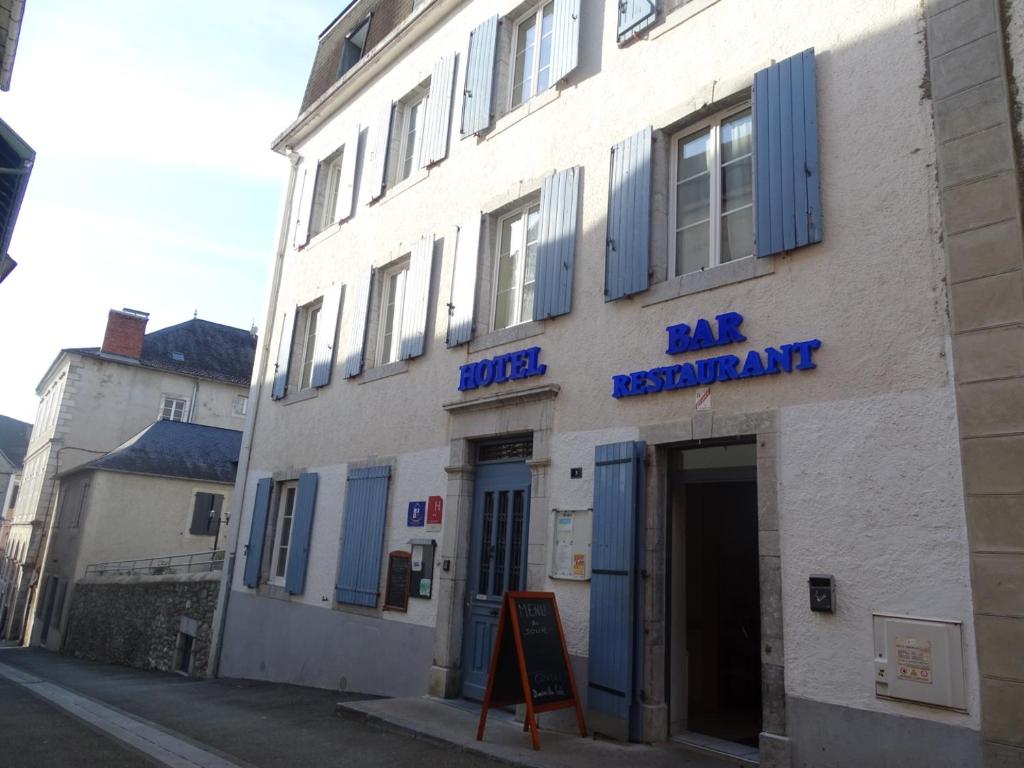 Tardets-SorholusHotel de la poste的白色的建筑,在街上有蓝色百叶窗