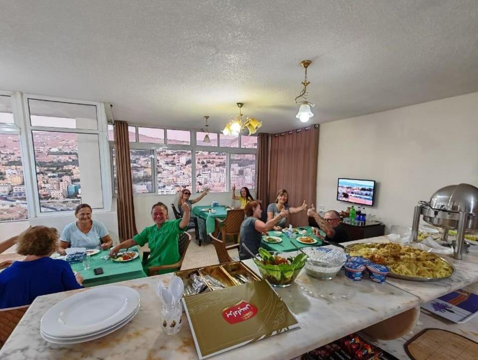 瓦迪穆萨iHome Petra的一群人坐在桌子旁吃着食物