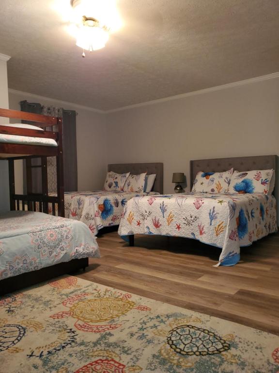 默特尔比奇Downtown MB House NEW furniture的一间卧室配有三张床和两张地毯