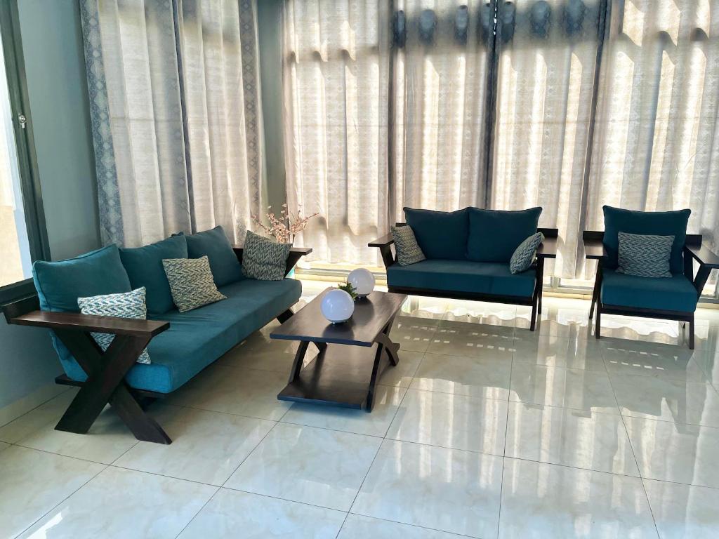 布琼布拉Ruhuka House的客厅配有蓝色的沙发和两把椅子