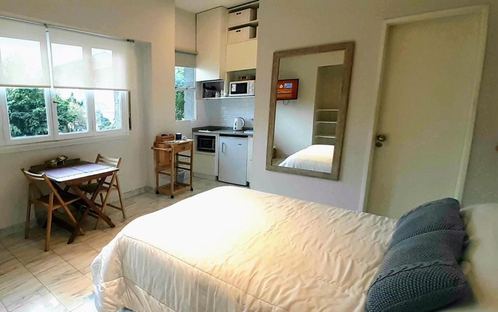 布宜诺斯艾利斯Apartamento centrico的一间带白色床的卧室和一间厨房