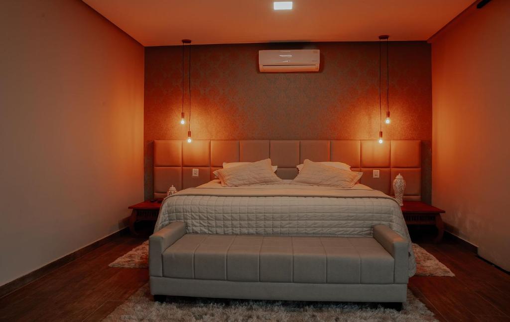 卡皮托利乌Pousada Quinta dos Cabeças的一间卧室配有一张带橙色墙壁的大床