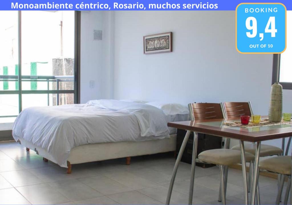 罗萨里奥Monoambiente Céntrico, Nuevo, Cochera y Muchos mas servicios的一间卧室配有一张床和一张桌子及椅子