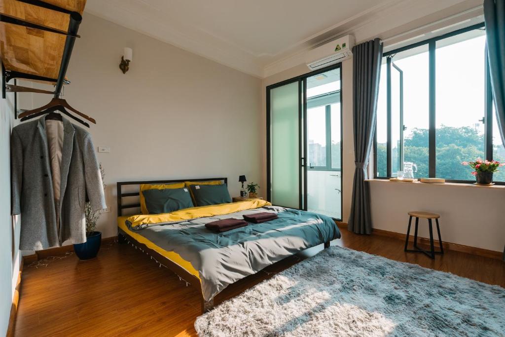 河内LIF HOMES - ngõ 15 P. Hồ Giám - by Bayluxury的一间卧室配有一张带地毯的床和大窗户