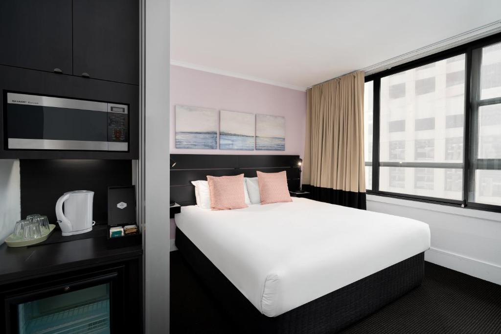 悉尼柏伟诗城市中心酒店的酒店客房设有白色的床和窗户。