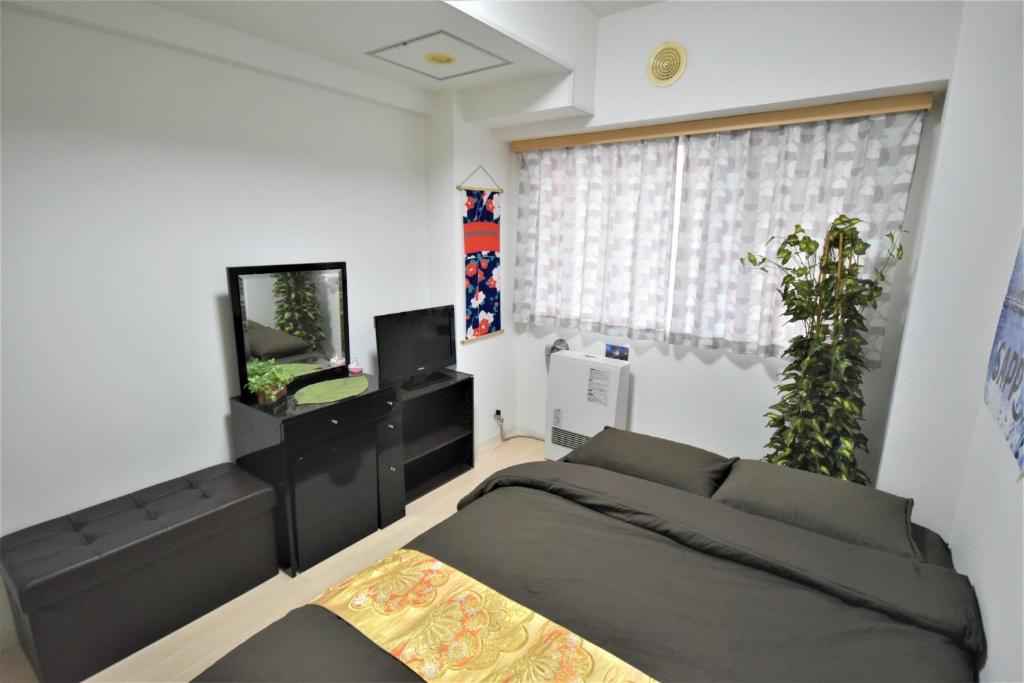 札幌Carid Shiraishi In front of the station / Vacation STAY 6173的一间卧室配有一张床和一台平面电视