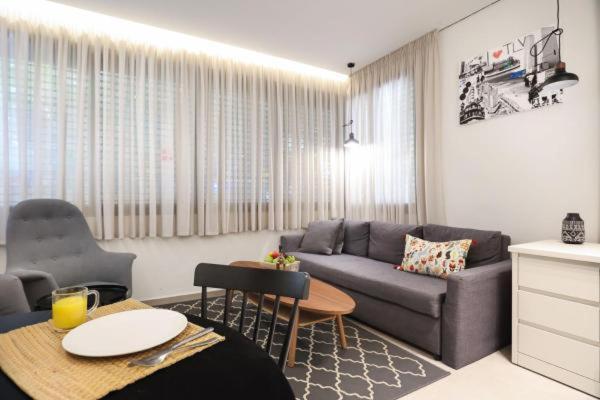特拉维夫Cozy Apartment in the Heart of Tel Aviv Sea N' Rent的客厅配有沙发和桌子