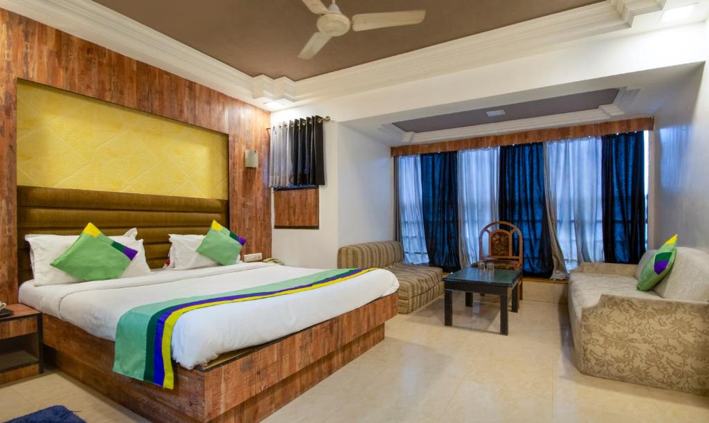 艾哈迈达巴德Treebo Trend Shree Krishna Palace的酒店客房,配有床和沙发
