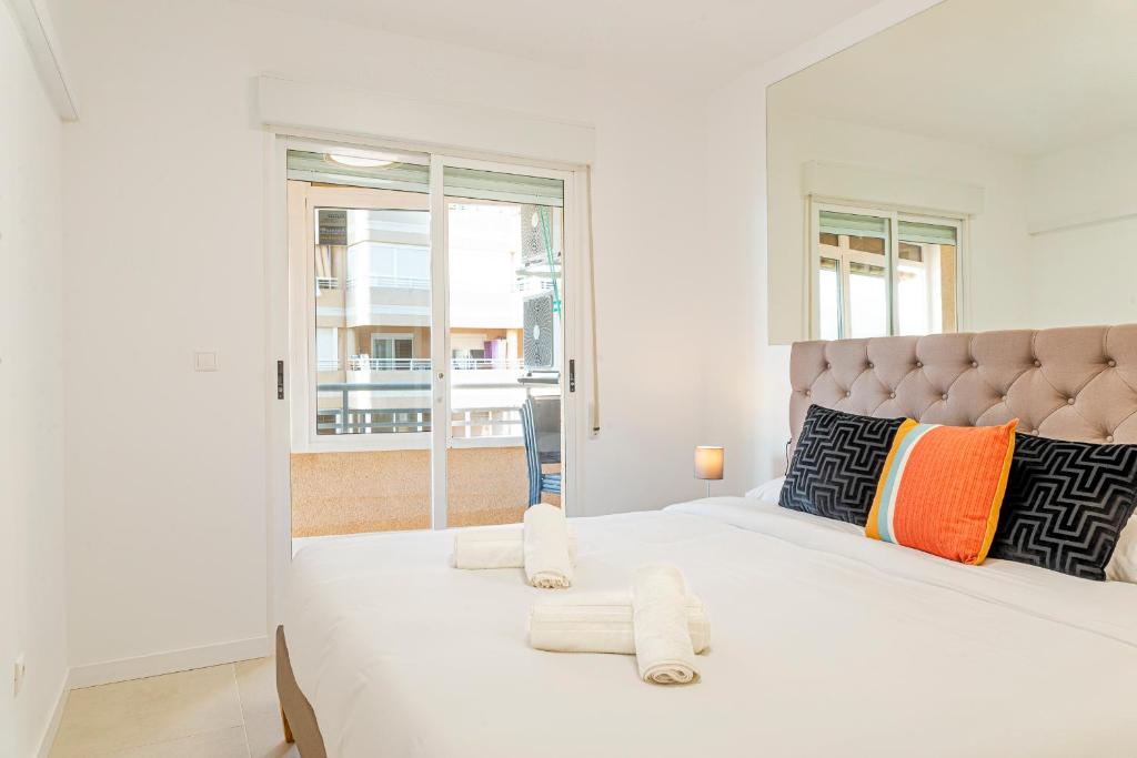 阿勒纳勒斯德尔索尔Myflats Premium Arenales Hills的白色卧室配有一张大床和毛巾