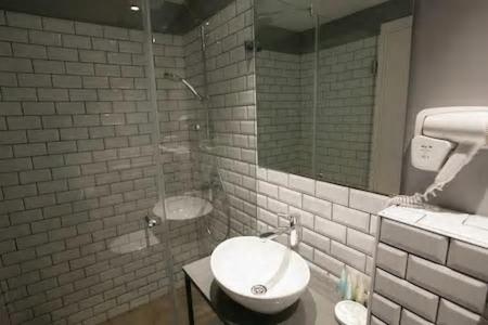 海法城市港口酒店的一间带玻璃淋浴和水槽的浴室